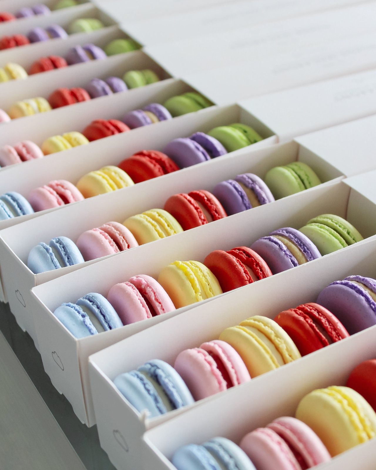 Varias cajas alineadas con macarons de colores listos para entrega