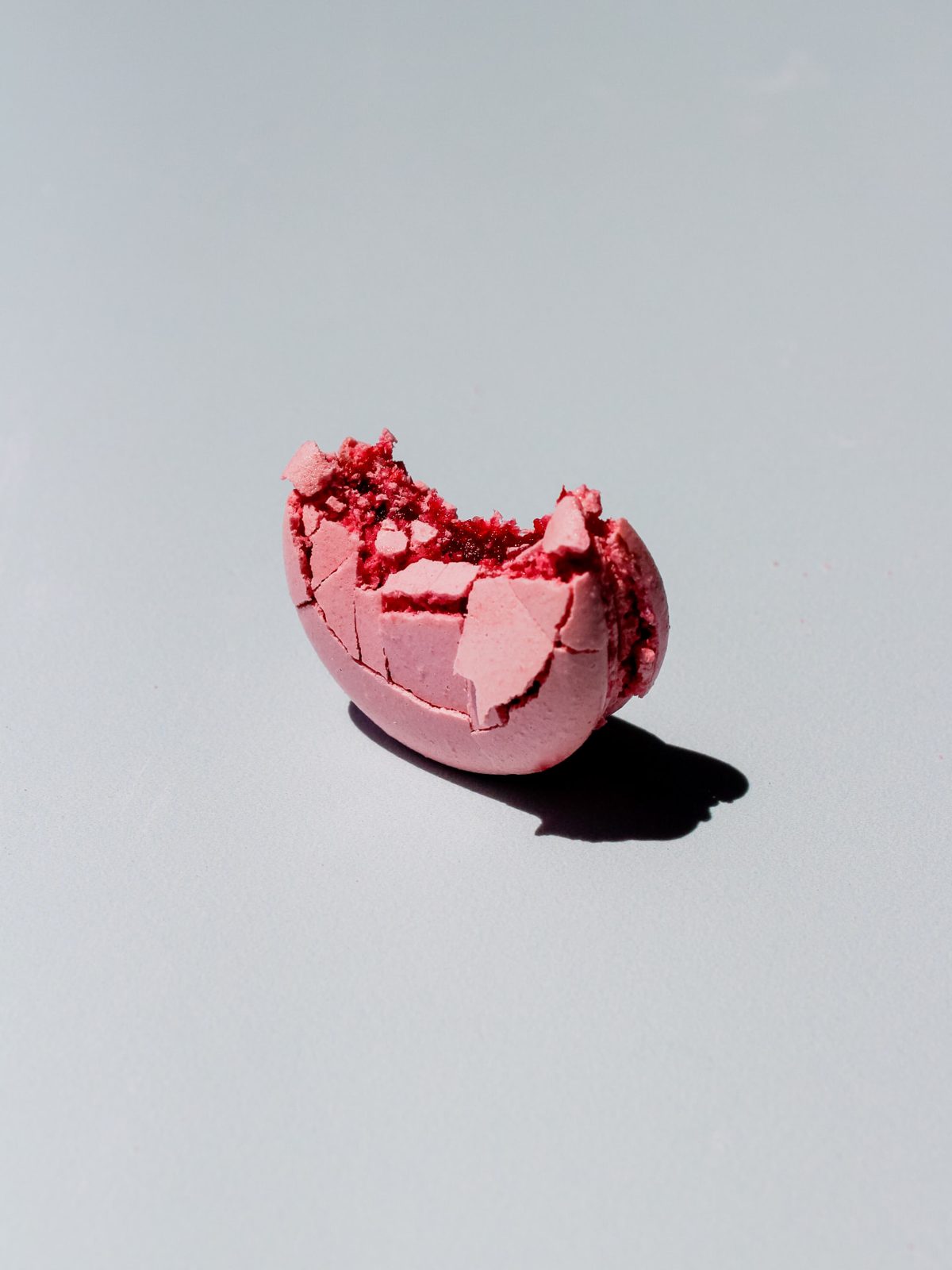 Macaron rosa partido mostrando su relleno